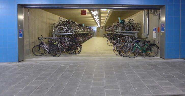 Blick von außen in die Fahrradgarage in München-Pasing, die mit Doppelstockparkern und Anlehnbügeln ausgestattet und sehr gut ausgelastet ist