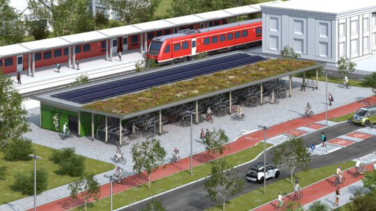 D-Visualisierung eines nachhaltig gestalteten Bahnhofsvorplatzes: Im Vordergrund verlaufen rot markierte Radwege und Gehwege, ein zweistöckiges Fahrradparkhaus mit begrüntem Dach bietet Platz für zahlreiche Fahrräder. Menschen bewegen sich zu Fuß, mit dem Fahrrad und E-Scooter fort. Im Hintergrund ist ein Regionalzug auf den Gleisen zu sehen. Die Anlage ist von Grünflächen und Bäumen umgeben und zeigt exemplarisch eine moderne Anschlussmobilität am Bahnhof.