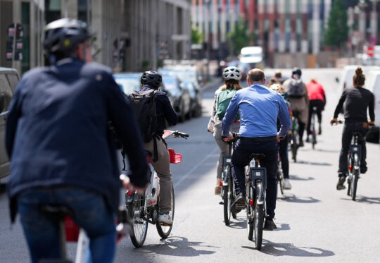 Blick auf eine Gruppe Fahrradfahrende von hinten fotografiert.
