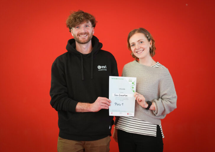 Zwei Personen, ein Mann und eine Frau halten ihr Gewinnerzertifikat hoch